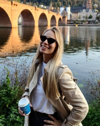 Rebeka Kardos mit Kaffeebecher vor der Alten Brücke in Heidelberg