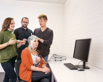 Studenten der Neuropsychologie während einer Messung der Hirnströme