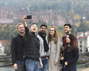 Internationale Studierende machen ein Selfie auf der alten Brücke