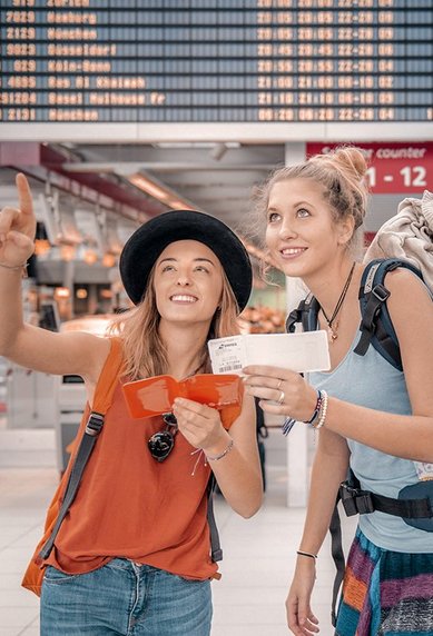 Zwei Studierende am Flughafen mit Gepäck