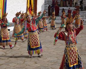 Auf dem Festival Paro-Tsechu in Bhutan tanzen Menschen in traditioneller Kleidung.