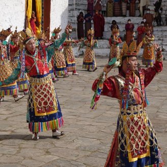 Auf dem Festival Paro-Tsechu in Bhutan tanzen Menschen in traditioneller Kleidung.