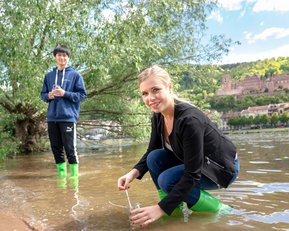 Studenten am Neckar in Heidelberg bei Entnahme von Wasserproben