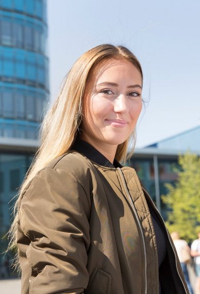 Portraitfoto Studentin vor dem Eingang der SRH Hochschule Heidelberg