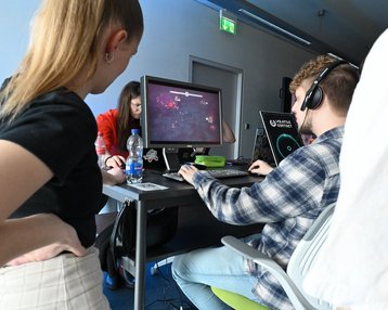 Studenten spielen gemeinsam am PC ein Game