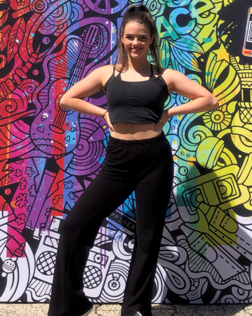 VR-Studentin Nadine Pfeifer steht vor einer bunten Graffiti Wand