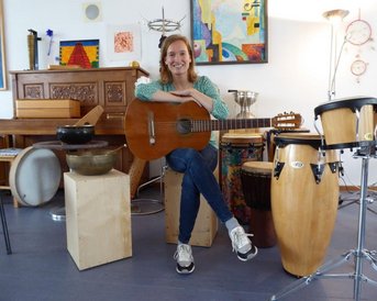 Alumna Verena Jungwirth mit Guitarre in der Hand