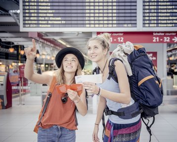 Zwei Studierende am Flughafen mit Gepaeck